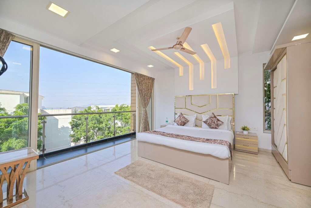 Spacious modern bedroom with a sleek design, large windows, and scenic outdoor view.